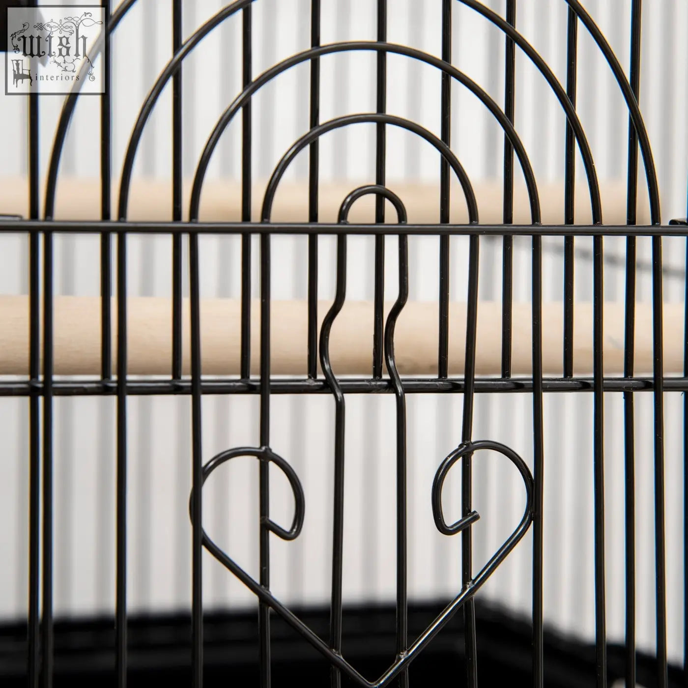 Black metal bird cage with heart accents wooden perches plastic food containers for feathered friends like finch and budgie
