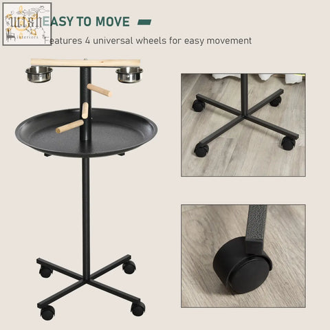 Black metal bird stand with wooden perches, two stainless steel bowls, and round tray on four wheels for parrots
