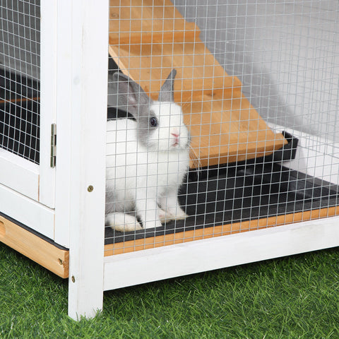 A white and gray rabbit with upright ears sits inside a yellow pawhut rabbit hutch living house with wooden run box