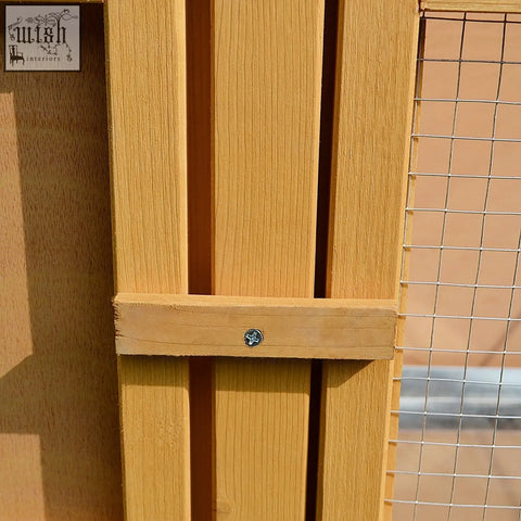 Light brown fir wood panel with vertical slats and silver screw on the back of pawhut rabbit hutch for small animals