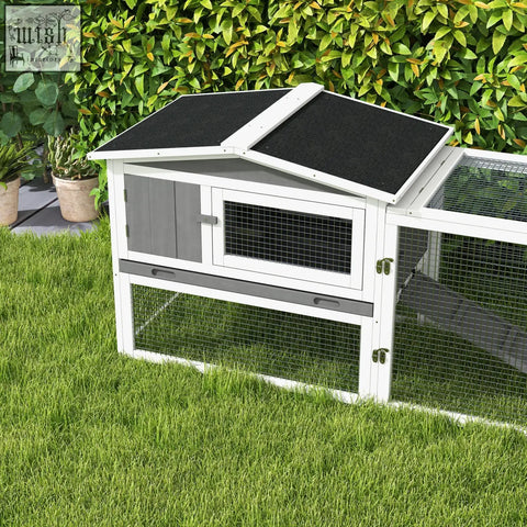 White and gray wooden rabbit hutch with asphalt roof panels and wire mesh sides for outdoor use by PawHut main house