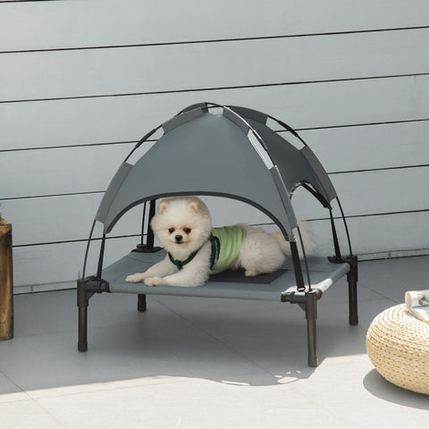 Gray elevated pet bed with black frame and breathable mesh canopy featuring a small white dog lounging comfortably