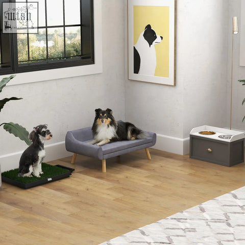 Gray upholstered dog bed with wooden legs next to pawhut stainless steel raised dog bowls and 21l storage drawer