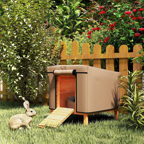 Beige oxford fabric hutch cover on a brown rabbit hutch with wooden ramp and slatted door in a garden setting