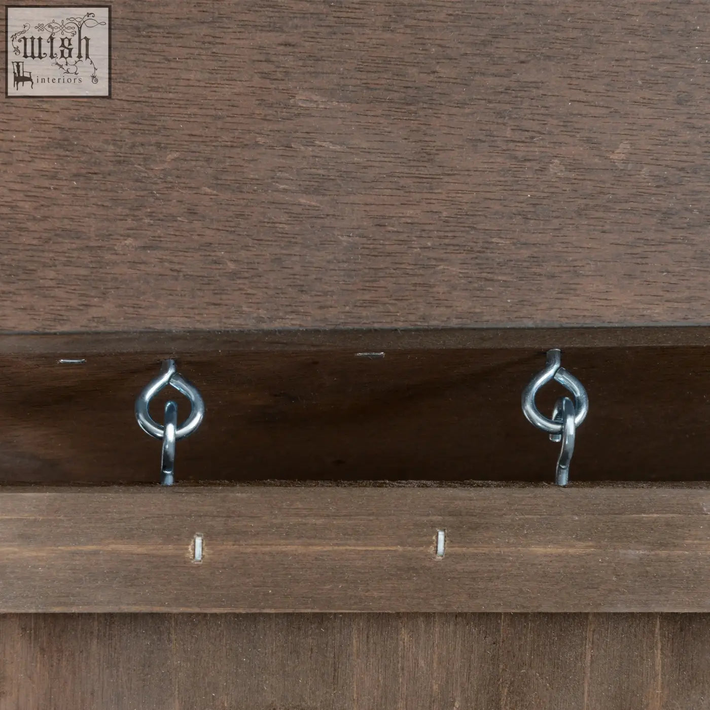 Two shiny silver metal hooks mounted on dark brown fir wood guinea pig hutch for secure bunny cage setup