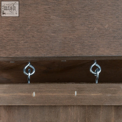 Two shiny silver metal hooks mounted on dark brown fir wood guinea pig hutch for secure bunny cage setup