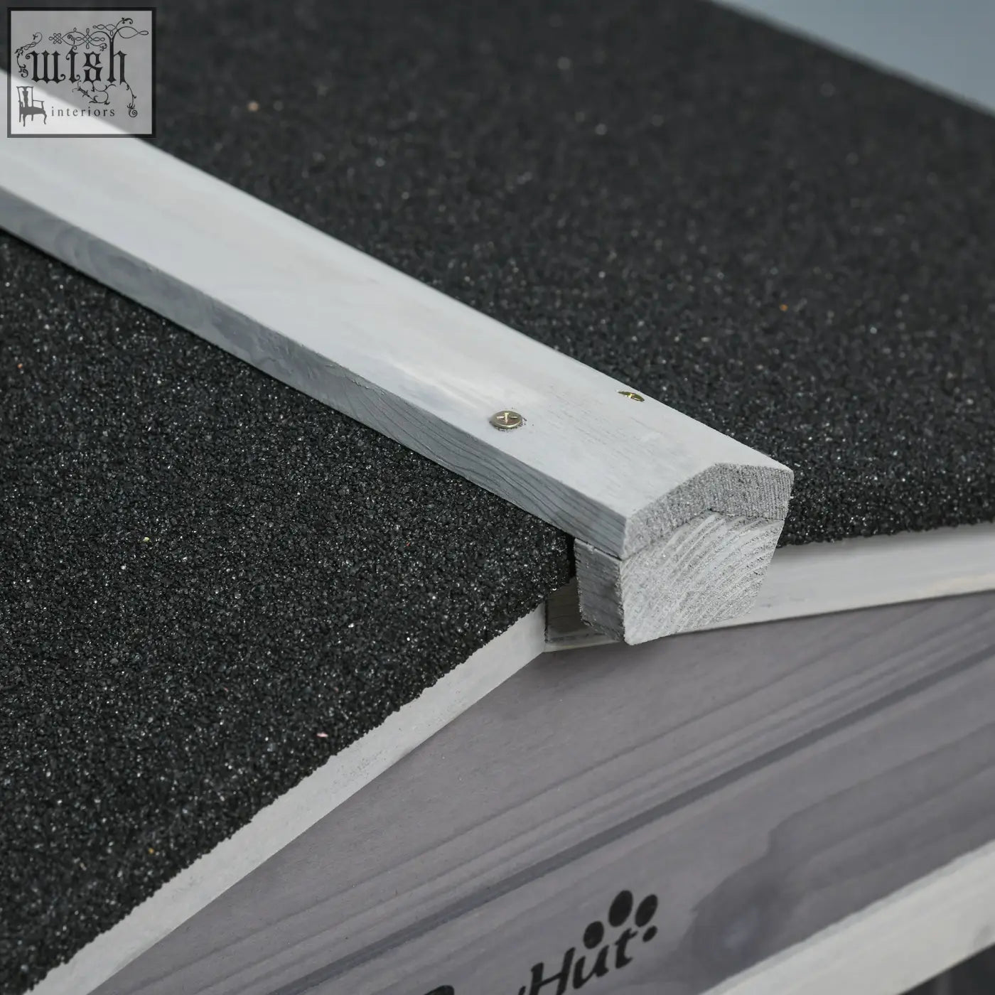 Light gray solid fir wood trim with a weathered finish on the edge of a pawhut guinea pig cage roof