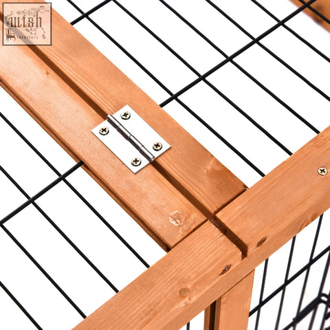 A silver metal hinge attached to light brown wooden beams on the enclosed main house of a pawhut wooden rabbit hutch