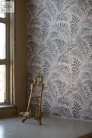 Antique gold-colored ornate easel with art nouveau dancing leaves design holding peace in blue hues wallpaper made from ethically sourced materials