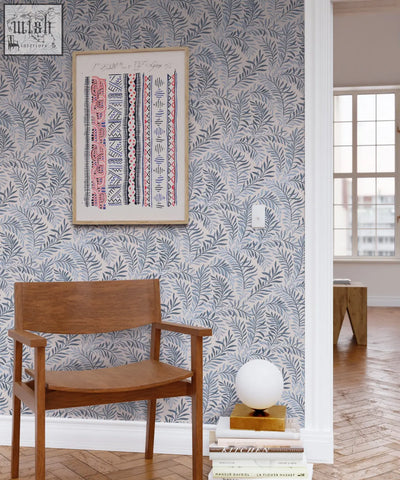A minimalist wooden armchair with smooth medium-toned finish paired with peace in blue hues wallpaper featuring dancing leaves and art nouveau style using ethically sourced materials