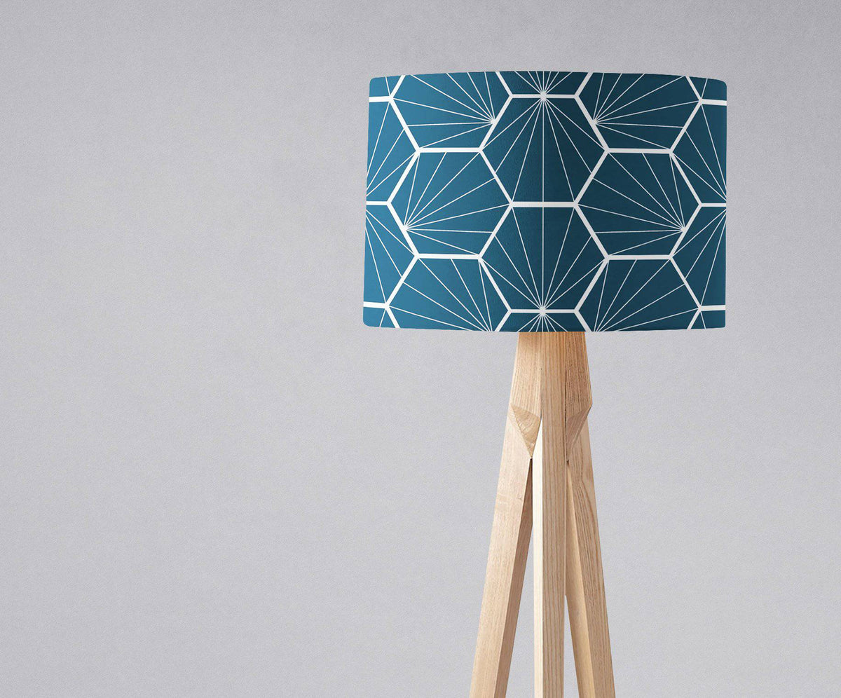 Peacock blue table lamp with a white hexagon design and a light wood tripod base
