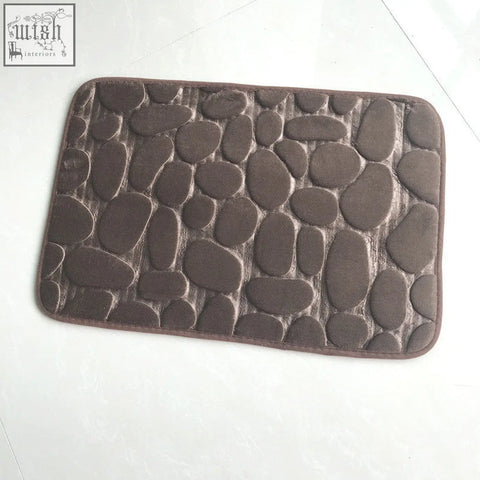 Brown pebble textured floor mat with soft memory foam surface and rounded edges perfect for water absorption
