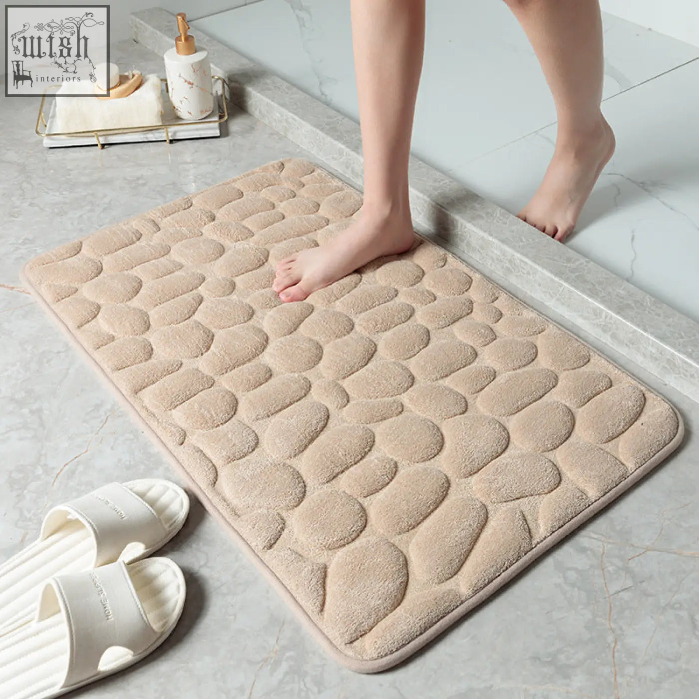 Beige pebble stone bathroom floor mat with soft plush memory foam surface and rounded edges for water absorption