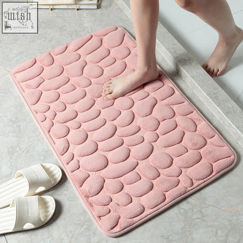 Pink pebble textured bath floor mat with soft plush memory foam material for water absorption and bathroom use