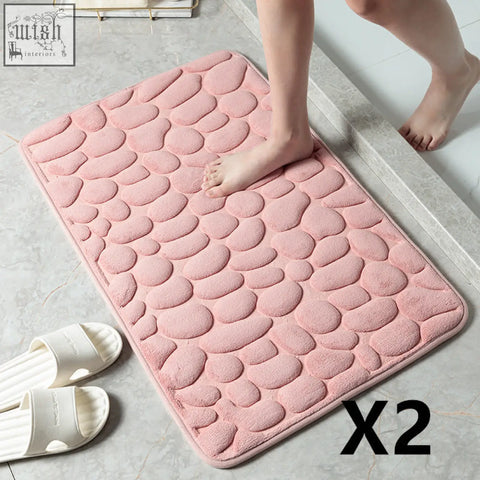 Pink pebble textured bathroom floor mat with soft plush memory foam for water absorption and toilet door use