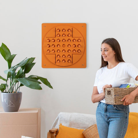 Orange square wall-mounted sensory play panel with raised peg solitaire bumps for solo test in recommended age range