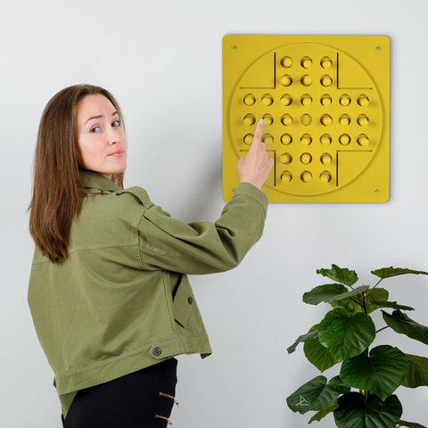 Yellow square peg solitaire board with raised circular pegs designed for solo test and age range play