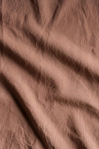A soft crinkled taupe percale duvet cover with subtle sheen and gentle folds for a cozy bedroom vibe