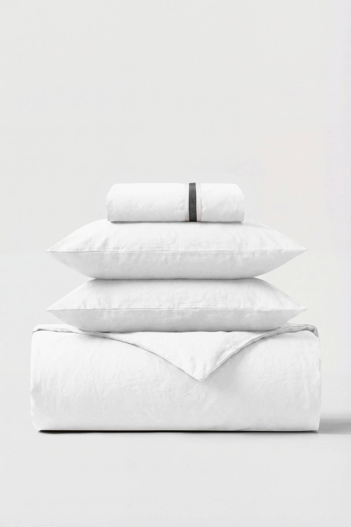 White cotton percale essentials bedding set with subtle black woven band on rolled pillowcase