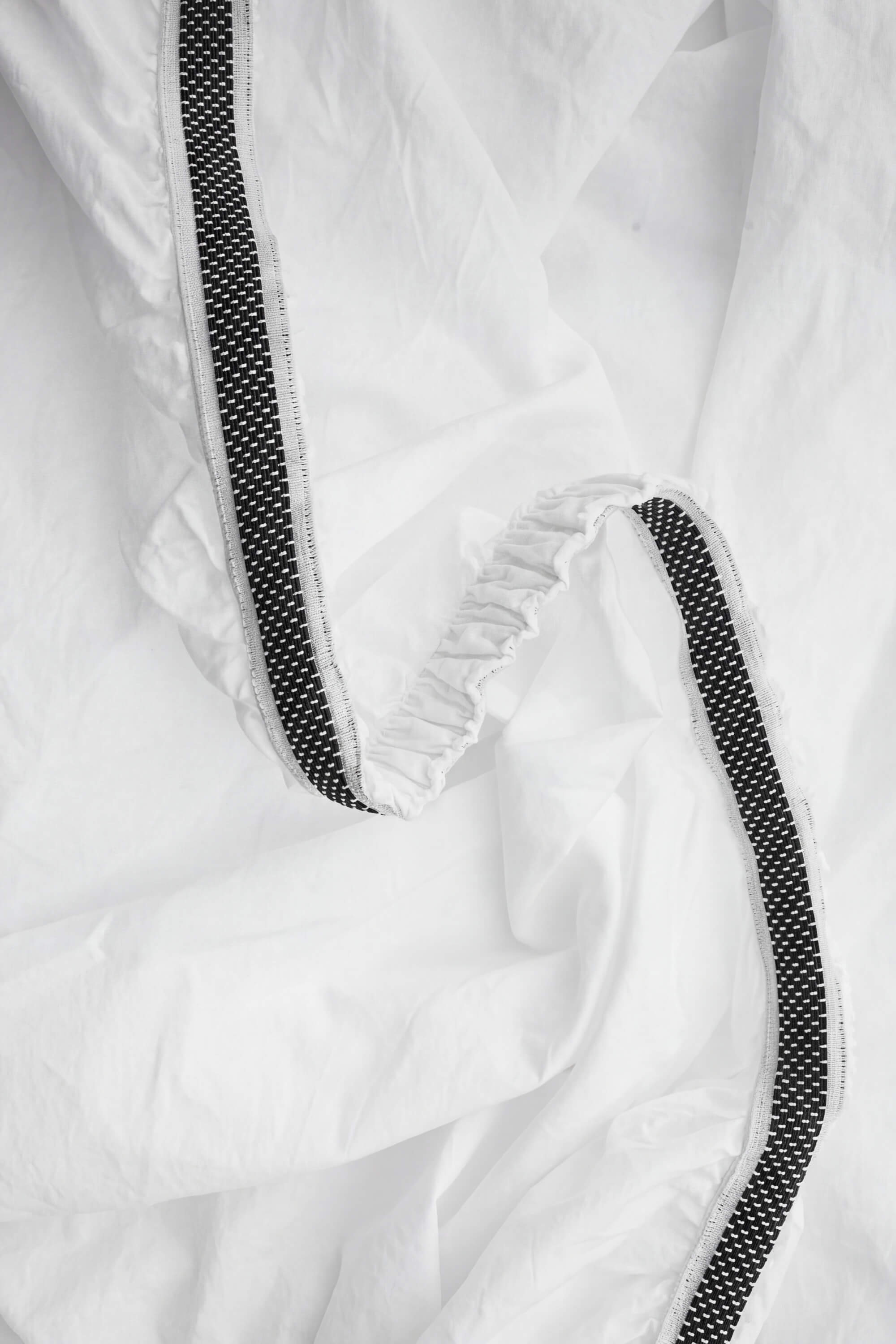 White percale bedding set with black dotted trim and elasticated edge for a snug fit on the mattress