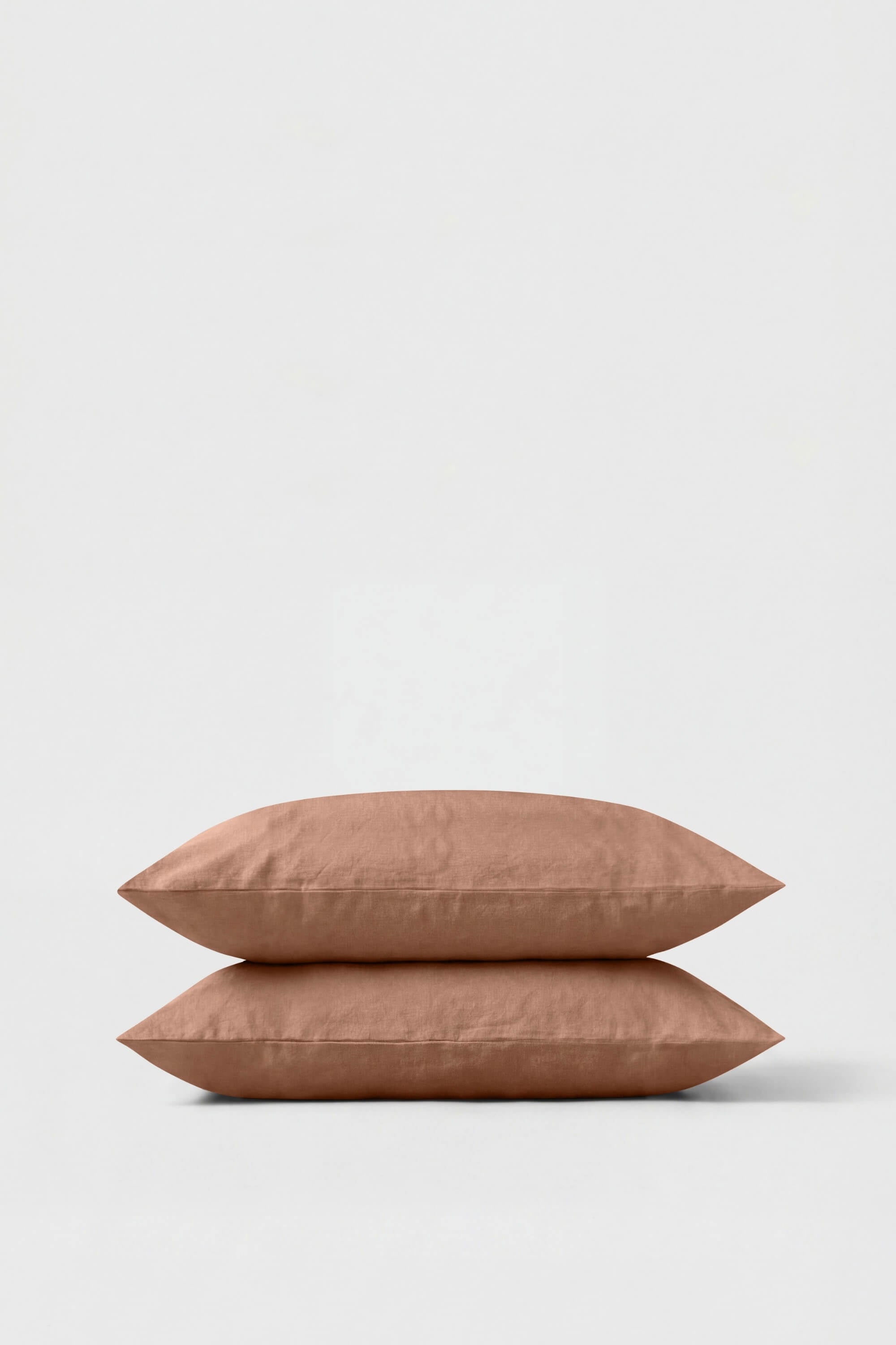 Two terracotta-colored percale pillowcases made of soft textured fabric in a percale pillowcase pair
