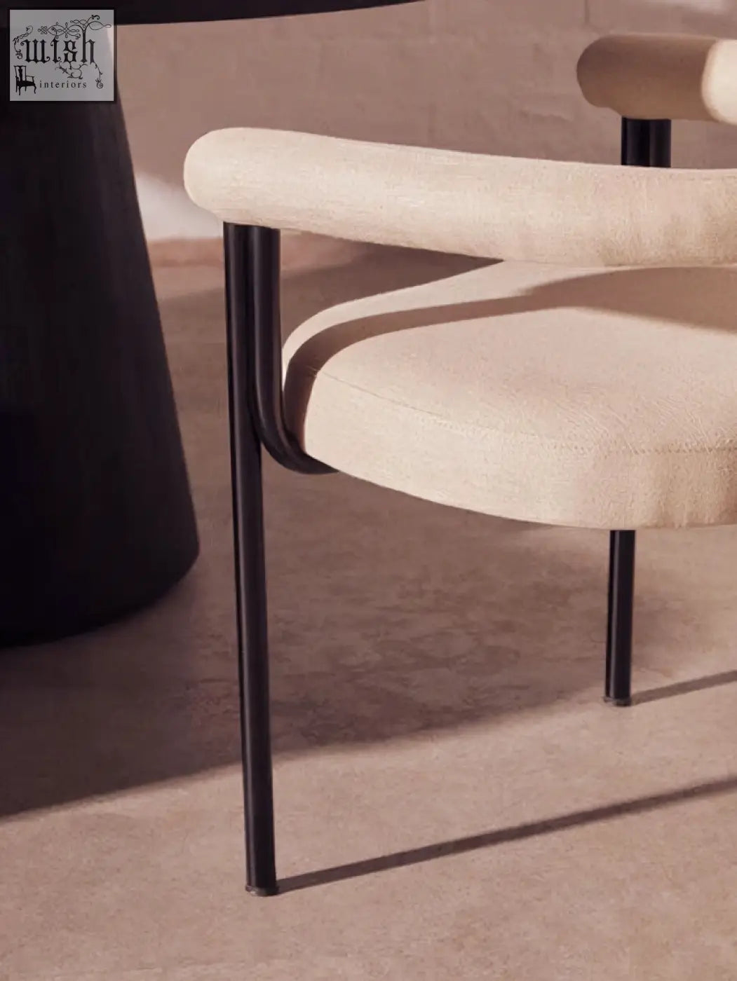 Beige perdoba cream texture linen dining chair with sleek black metal legs and curved armrests for stylish dining