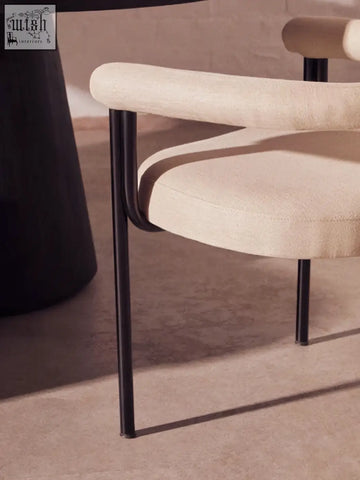 Beige perdoba cream texture linen dining chair with sleek black metal legs and curved armrests for stylish dining