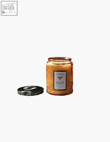 Golden amber glass peregrine scented candles gift jar with embossed patterns and black lid with silver leaf design