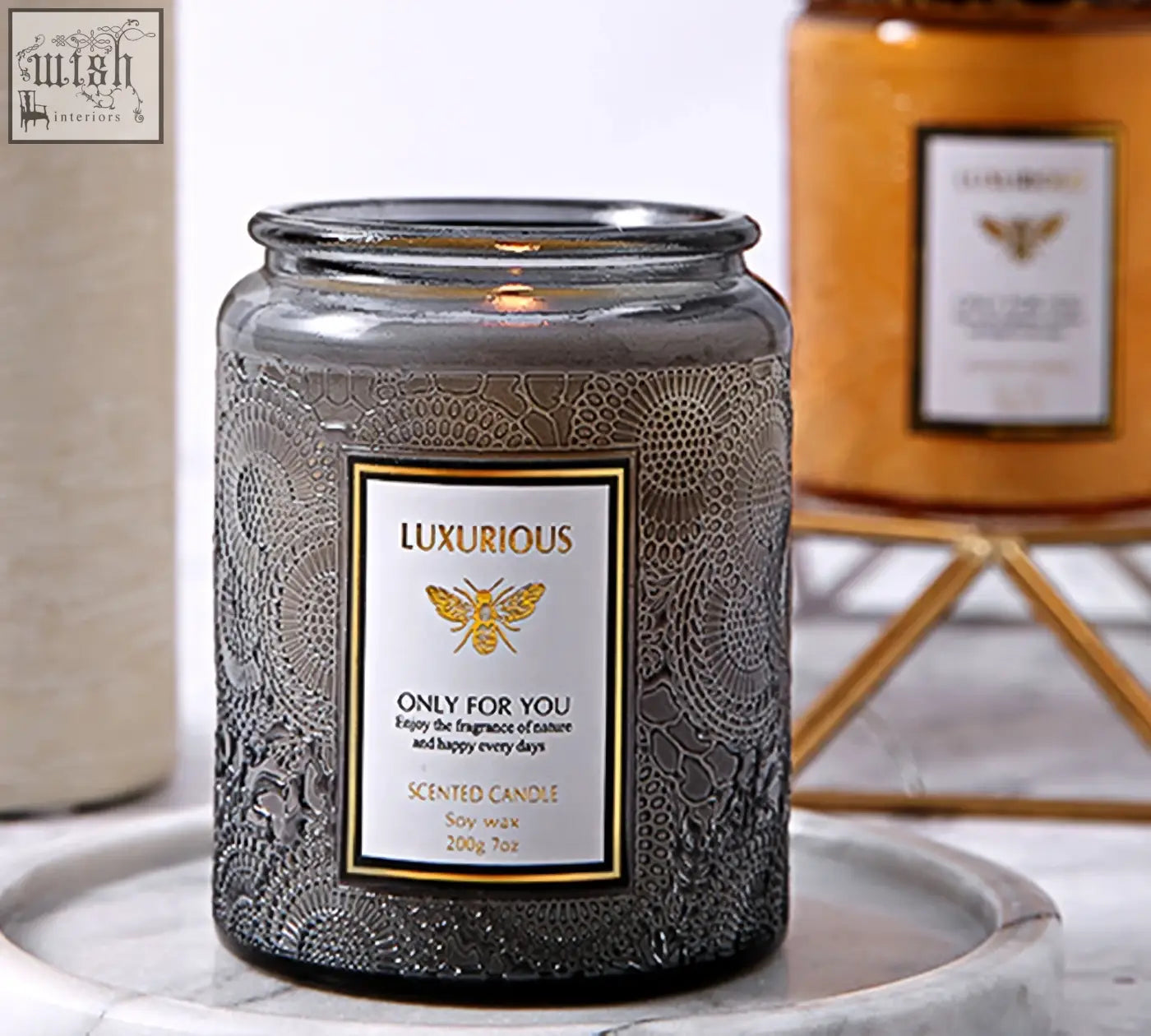 A gray glass scented candle with floral etching and gold bee logo labeled luxurious only for you perfect scented candles gift