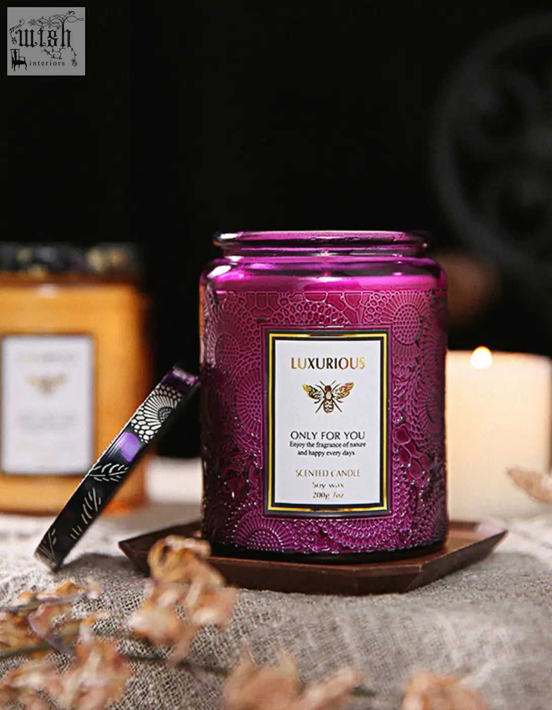 A vibrant purple glass jar scented candle with lace pattern and gold bee label perfect as a candles gift