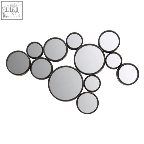 A persephone black multi wall mirror set with scattered circular black framed mirrors in an asymmetrical pattern