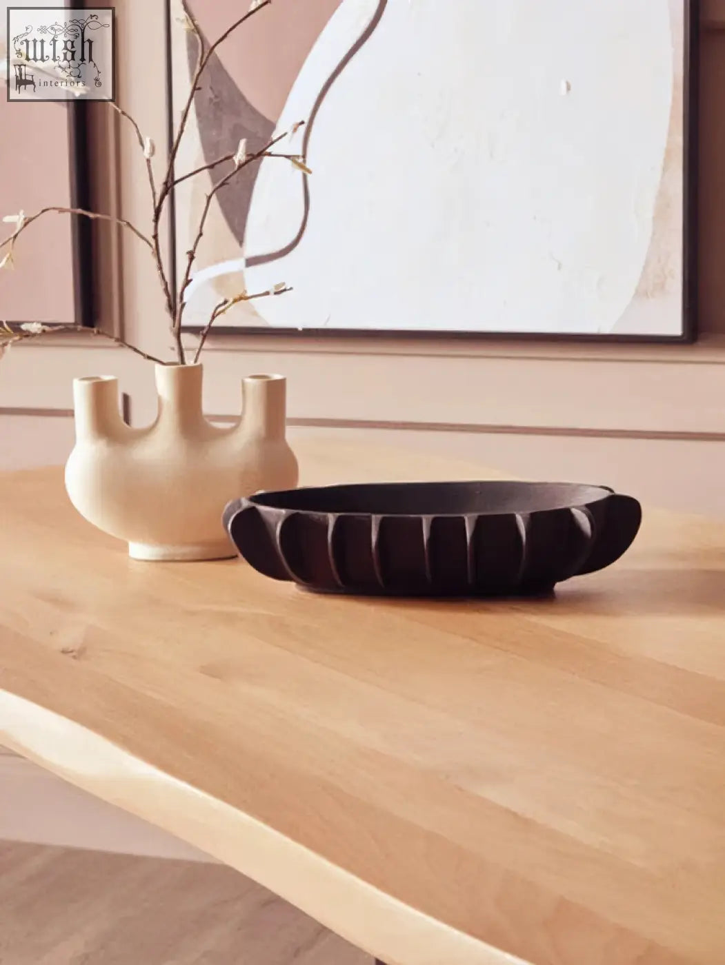 Cream-colored ceramic vase with three openings shown on a live edge mango wood dining table with black metal legs