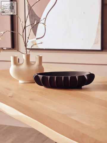 Cream-colored ceramic vase with three openings shown on a live edge mango wood dining table with black metal legs