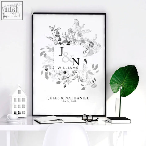 Black-framed wedding anniversary wall art print with personalised monogrammed initials and grayscale floral design