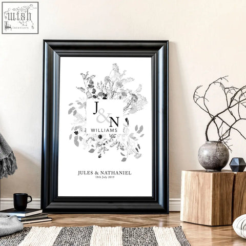 Black-framed personalised wedding anniversary wall art print featuring monogrammed initials and floral wreath design