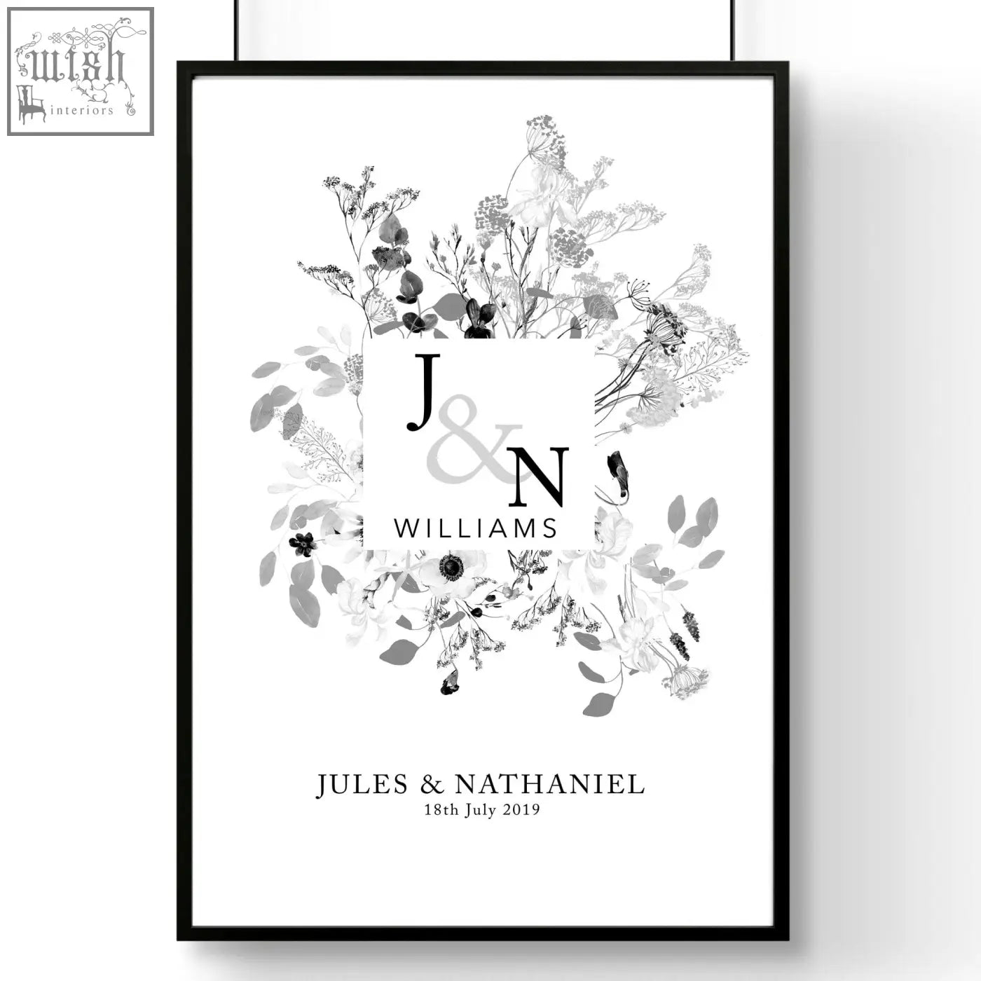 Black-framed personalised wedding anniversary wall art print with monogrammed initials and grayscale floral illustrations
