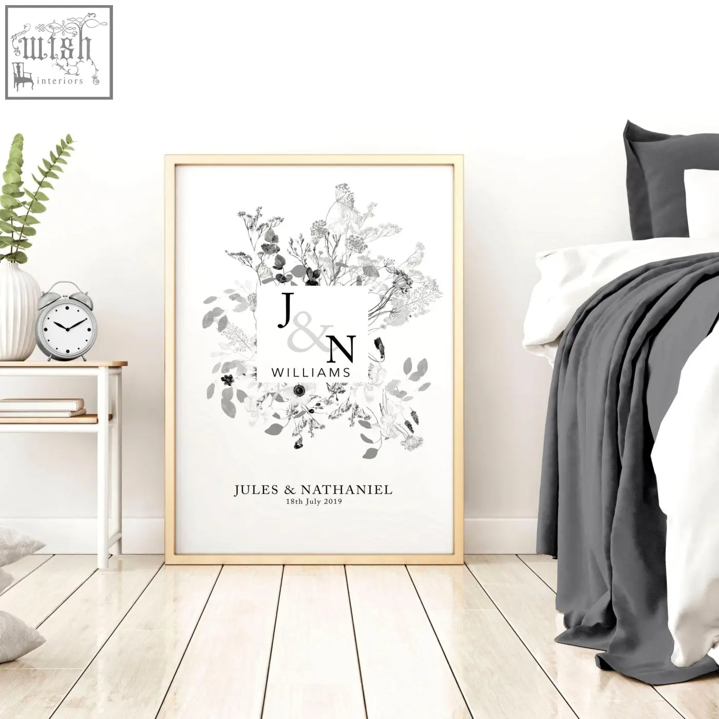 A framed black and white personalised wedding anniversary wall art print with floral monogram and initials j and n