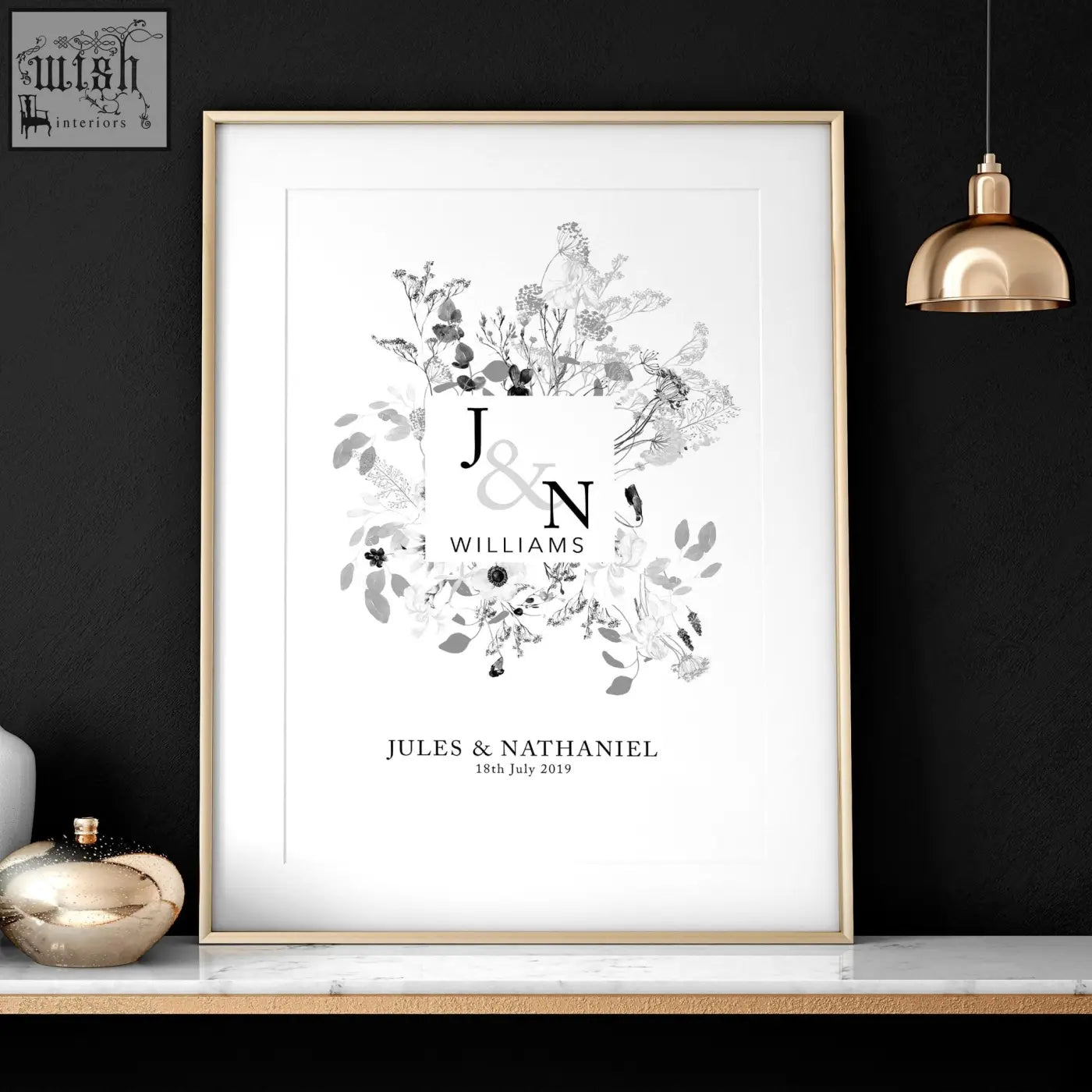 A personalised wedding anniversary wall art print with black and white floral design and gold toned frame featuring j and n
