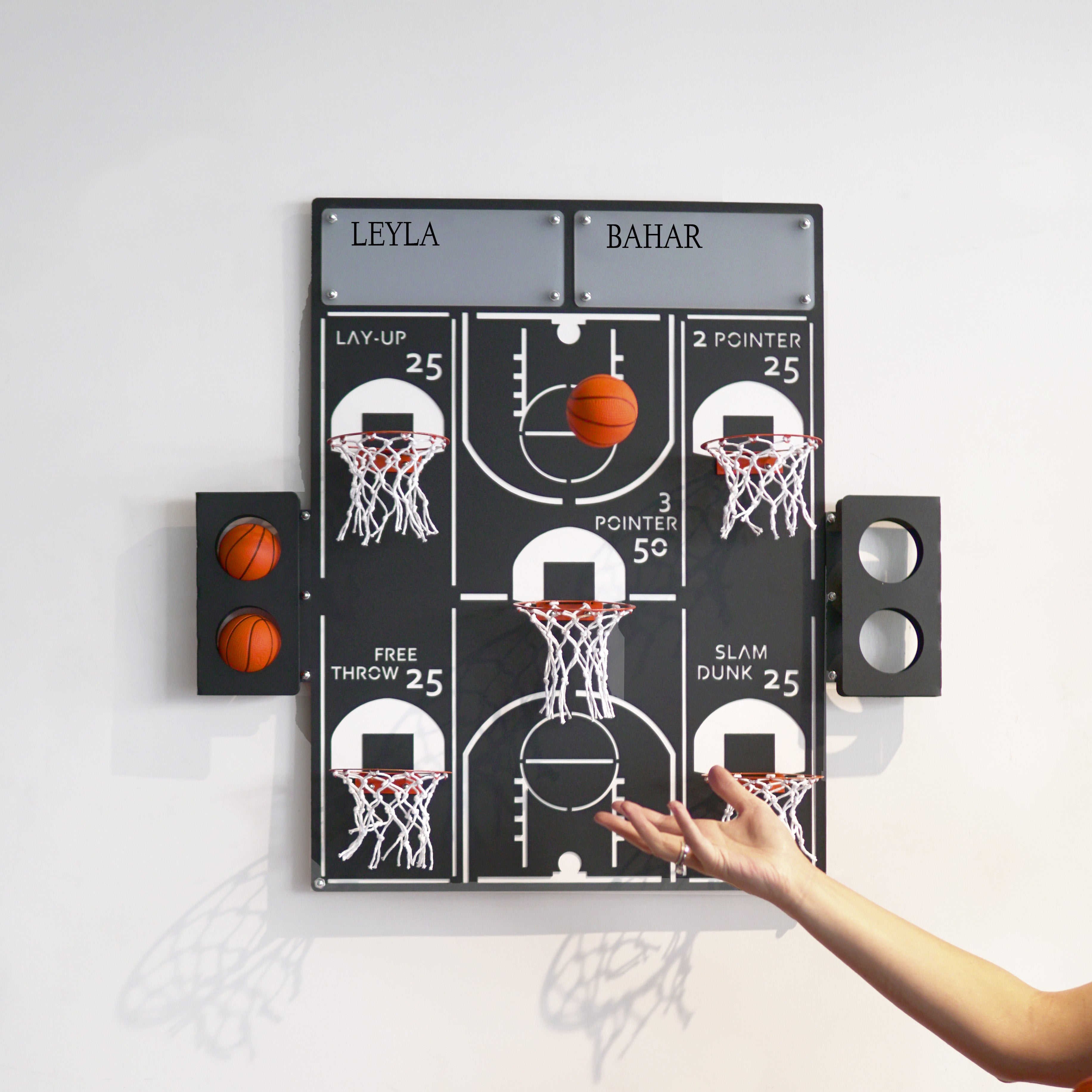 Black wall-mounted basketball wall game with white court markings and multiple mini hoops for all-star shots