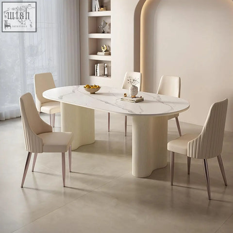 Modern oval dining table with white marble top and cream peru dining chair featuring ribbed pedestal legs