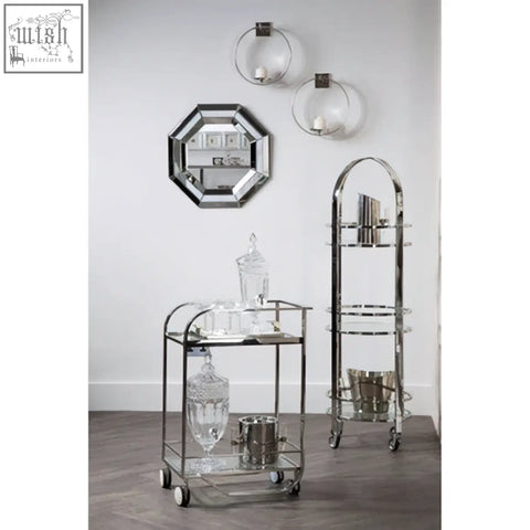 Chrome-finished bar cart with glass shelves and wheels featuring a sleek modern design for petillo octagonal wall mirror display