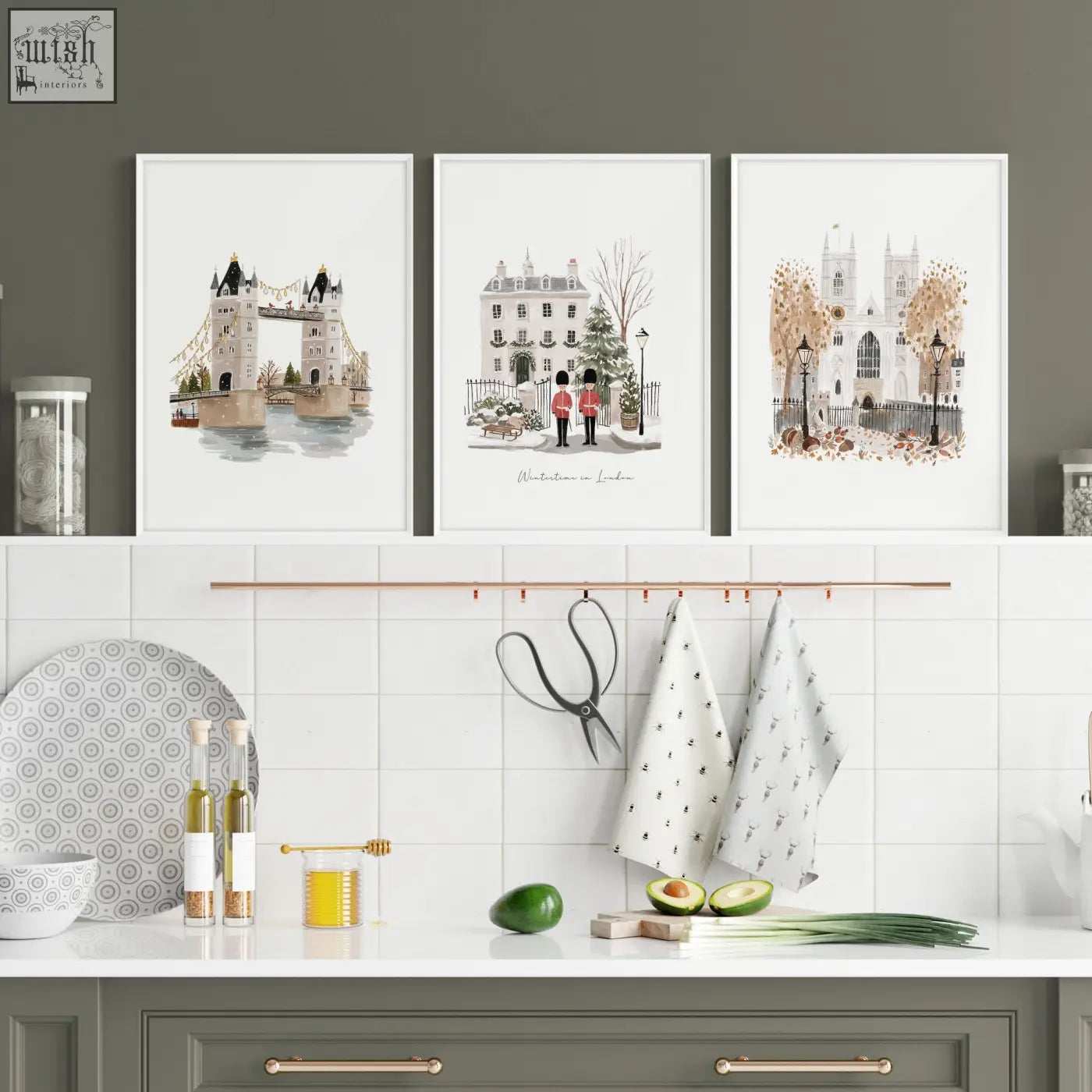Three framed watercolor art prints of london bridge travel wall art hang above a kitchen counter in wintertime style