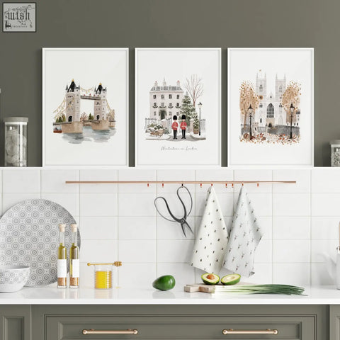 Three framed watercolor art prints of london bridge travel wall art hang above a kitchen counter in wintertime style