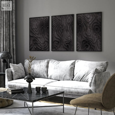 Black marble coffee table with sleek metal legs paired with dark brown topographic abstract wall art prints for living room