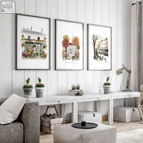 Three framed watercolor illustrations of london scenes in terracotta hues hanging on a white wooden wall for wall living room decor