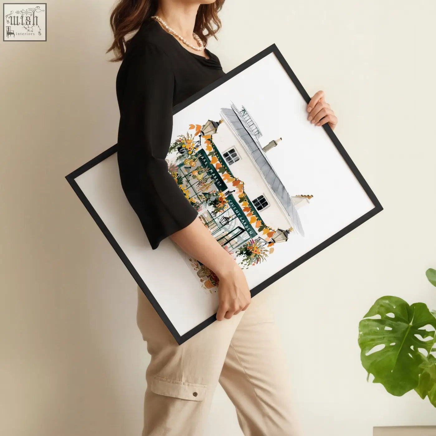 Black-framed living room wall art print featuring charming illustrated building with green awnings and autumn decor