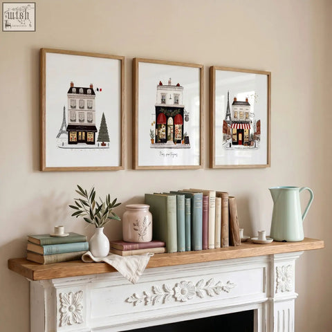 Three framed illustrations of parisian buildings and the eiffel tower in light wood frames boutique street scenes pour toujours