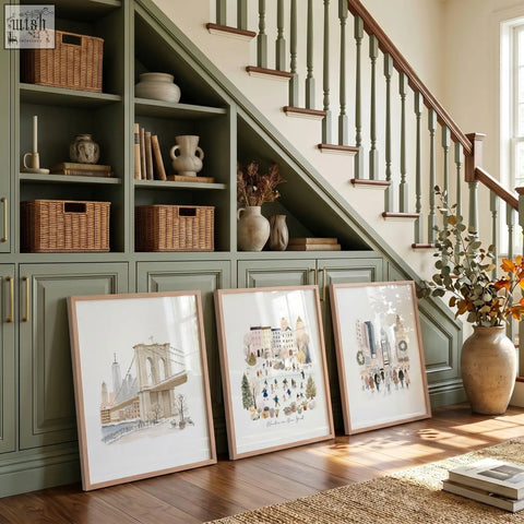 Three framed winter in new york art prints with light wood frames leaning under stairs green cabinet travel wall art