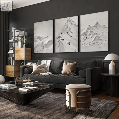 Dark gray upholstered sofa with beige and taupe pillows in front of scandi mountain climbers wall art on living room walls