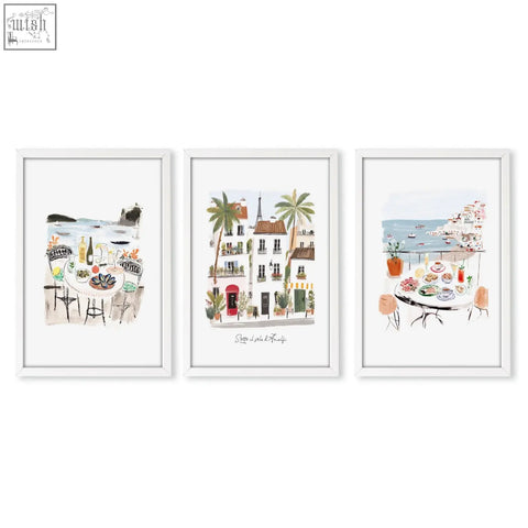 Set of three white-framed watercolor wall art prints featuring coastal and parisian scenes sotto il sole
